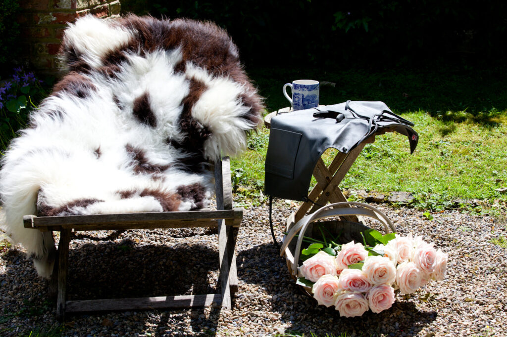 Rare breed Sheepskin rug with Brown and White Natural markings on a deck chair in a garden.