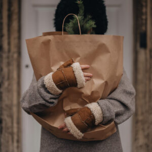 lady wearing fingerless mittens holding paper back
