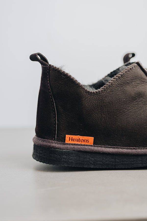 Detailed shot of orange Heatons brand label on brown sheepskin slipper