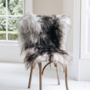 Natural grey undyed Icelandic Sheepskin Rug draped over a wooden chair settled in a window