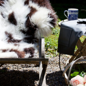 Rare breed Sheepskin rug with Brown and White Natural markings on a deck chair in an English Country Garden.